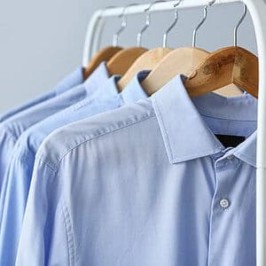 Rack with clean shirts on grey background