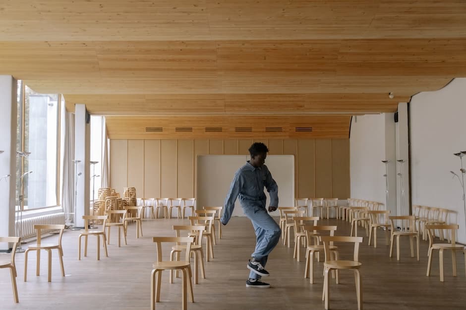 A Man Dancing Between Empty Chairs