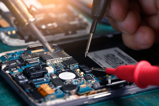 The asian technician repairing the smartphone's motherboard in the lab with copy space. the concept 